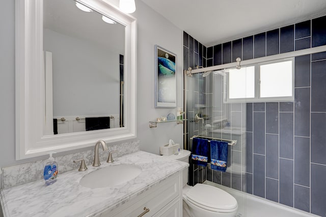 bathroom featuring an enclosed shower, vanity, and toilet