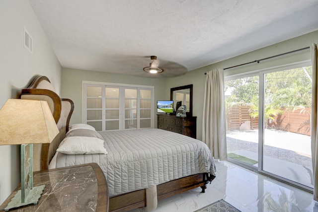 bedroom featuring french doors, ceiling fan, a textured ceiling, and access to outside