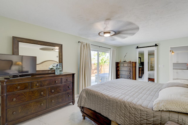 bedroom with ceiling fan, a barn door, a textured ceiling, and access to outside