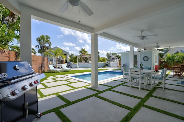 view of pool with ceiling fan, area for grilling, and a patio