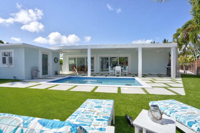 back of property featuring ceiling fan, a patio, and a lawn