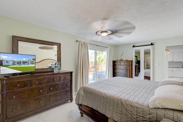 bedroom featuring ceiling fan, a barn door, access to outside, and a textured ceiling