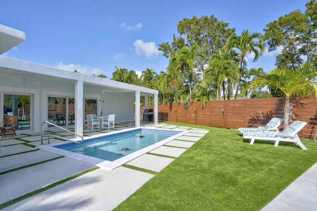 view of pool with area for grilling, a patio, and a lawn