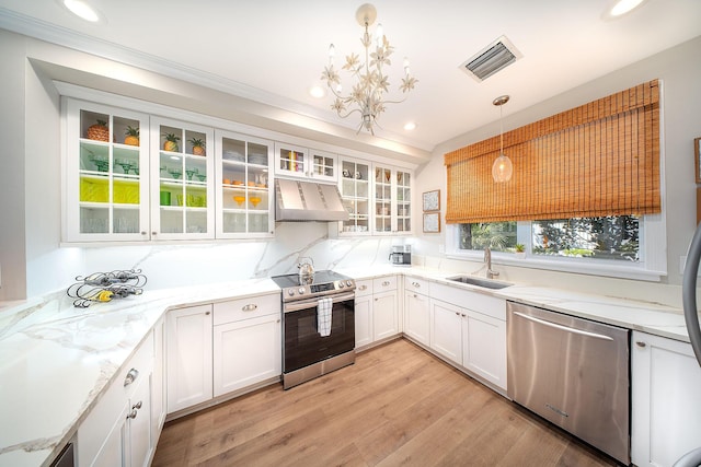 kitchen featuring stainless steel appliances, white cabinetry, sink, and decorative light fixtures