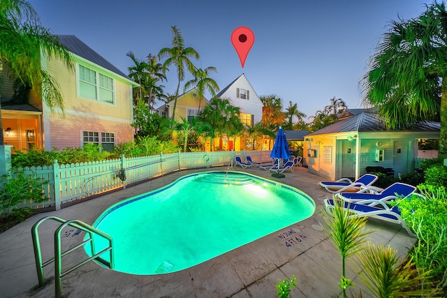 pool at dusk featuring a patio