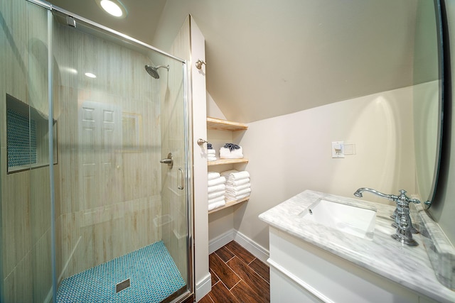 bathroom featuring a shower with door, vanity, and vaulted ceiling