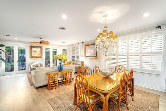 dining space featuring ornamental molding, ceiling fan with notable chandelier, and light wood-type flooring