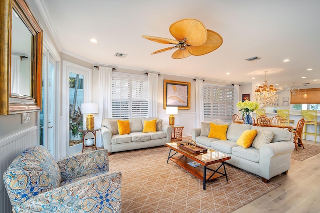 living room with an inviting chandelier, light hardwood / wood-style flooring, and ornamental molding