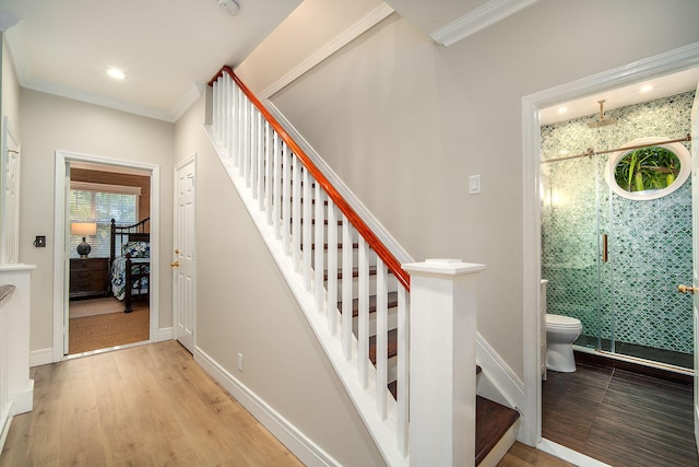 stairs featuring hardwood / wood-style flooring and ornamental molding