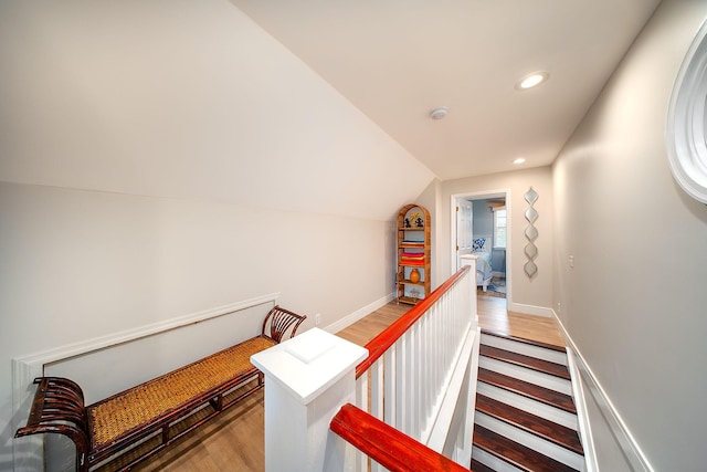 corridor with lofted ceiling and light hardwood / wood-style flooring