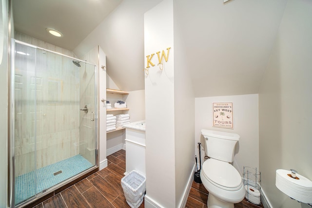 bathroom with toilet, lofted ceiling, and a shower with shower door