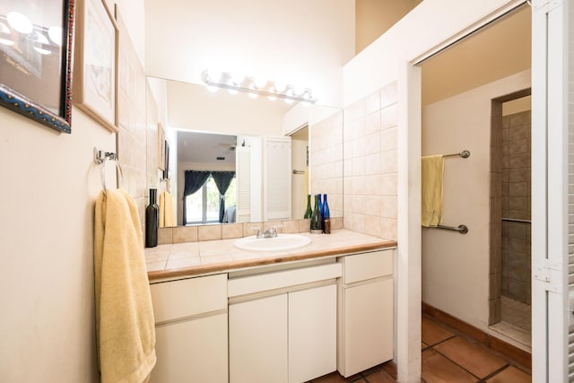 bathroom with vanity, a tile shower, and tile patterned floors