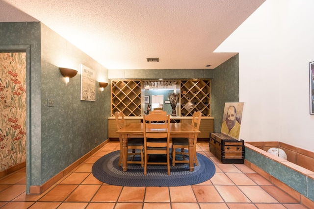 wine area featuring tile patterned flooring and a textured ceiling