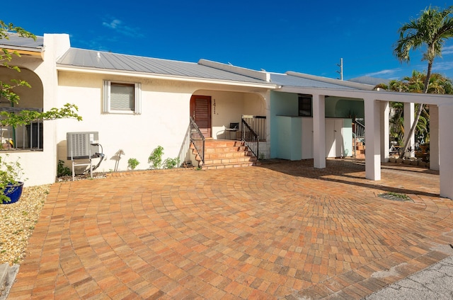 back of property featuring cooling unit and a carport