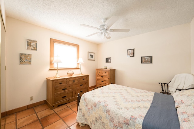 tiled bedroom with ceiling fan and a textured ceiling