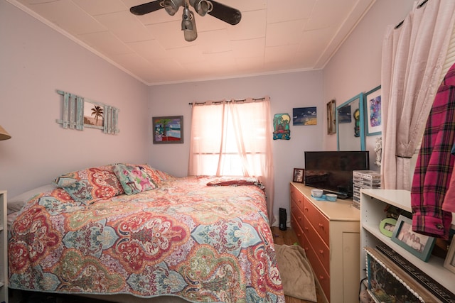 bedroom with ornamental molding, wood finished floors, and a ceiling fan