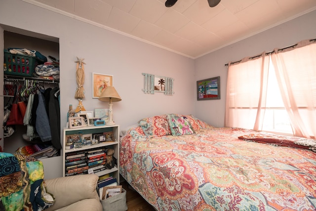 bedroom featuring wood finished floors, multiple windows, a closet, and crown molding