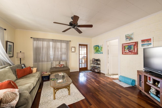 living room featuring ceiling fan, brick wall, wood finished floors, and crown molding