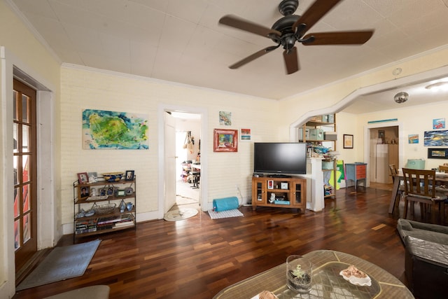 living room featuring a ceiling fan, crown molding, and wood finished floors