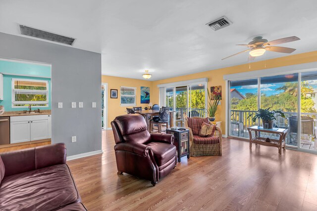 living room with sink, ceiling fan, and light hardwood / wood-style flooring