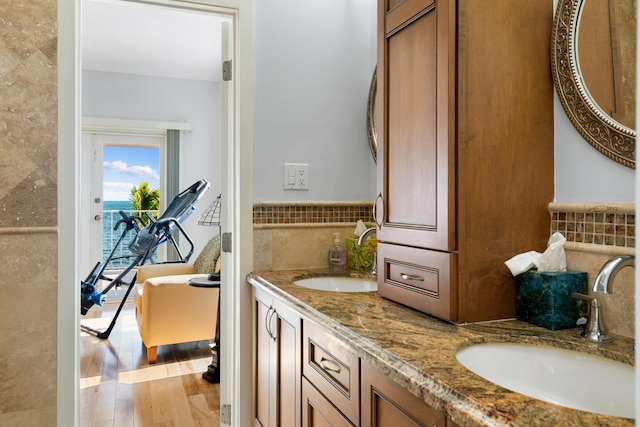 bathroom with hardwood / wood-style flooring, tile walls, and vanity