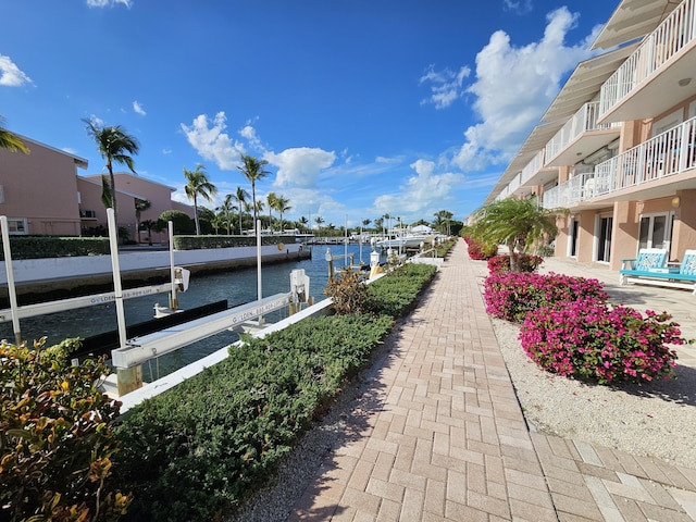 surrounding community with a water view and a boat dock