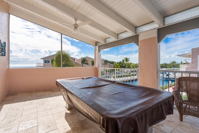 playroom featuring ceiling fan, a water view, and a balcony