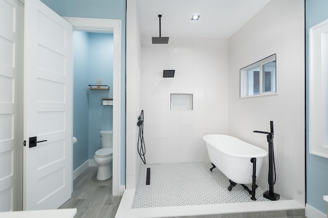 full bathroom featuring toilet, a walk in shower, and a freestanding bath