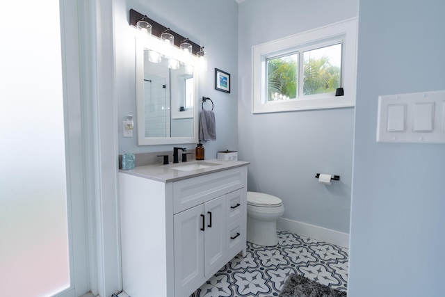 full bathroom featuring toilet, vanity, tile patterned flooring, baseboards, and walk in shower