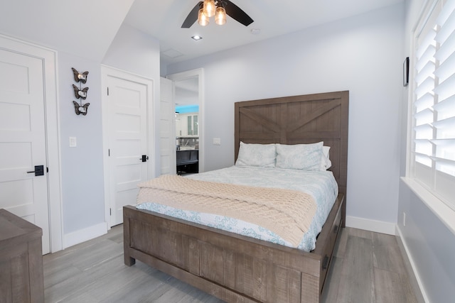 bedroom with light wood-style floors, multiple windows, and baseboards