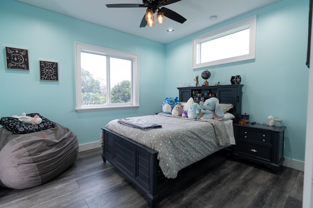 bedroom with dark wood-type flooring, multiple windows, a ceiling fan, and baseboards