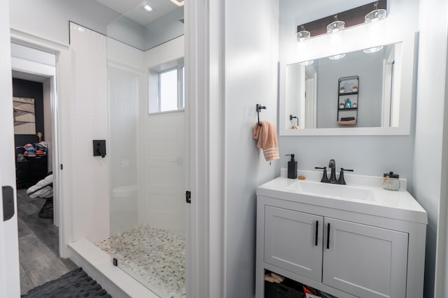 full bathroom with a shower stall, vanity, and wood finished floors