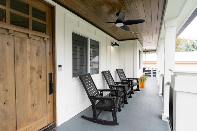 wooden deck with a porch and ceiling fan