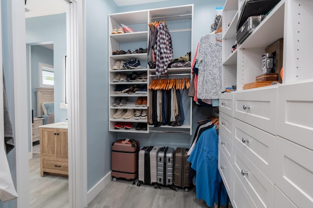 walk in closet with light wood-type flooring