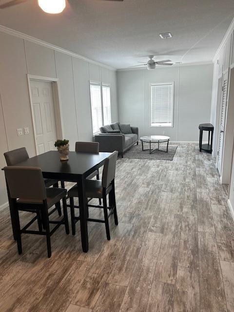 5413 3rd Ave, Stock Island, FL 33040 - dining space featuring ornamental molding, wood finished floors, ceiling fan, a decorative wall, and baseboards
