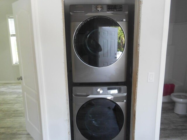 5413 3rd Ave, Stock Island, FL 33040 - laundry area with stacked washing machine and dryer, wood finished floors, and baseboards