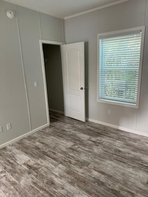 5413 3rd Ave, Stock Island, FL 33040 - unfurnished bedroom with crown molding, wood finished floors, baseboards, and a closet