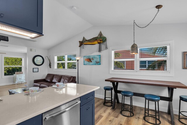 kitchen with blue cabinetry, a healthy amount of sunlight, dishwasher, and vaulted ceiling