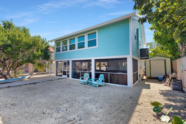 rear view of house with cooling unit, a patio area, and a sunroom