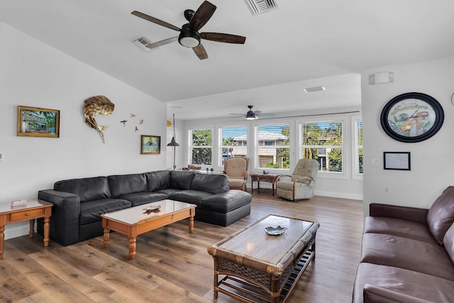 living room with ceiling fan, plenty of natural light, wood-type flooring, and vaulted ceiling