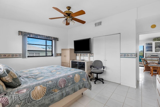 bedroom with light tile patterned flooring, ceiling fan, and a closet