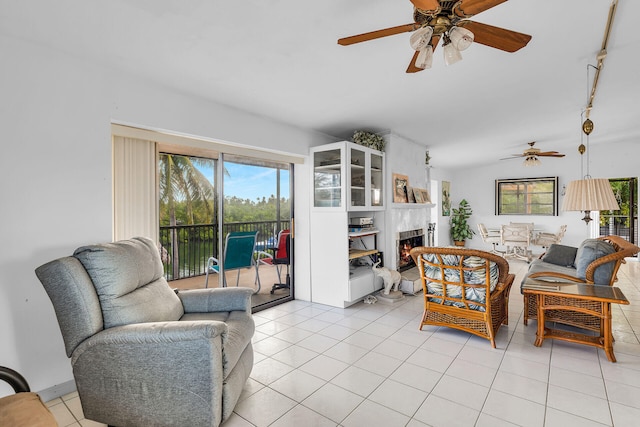 living room featuring light tile patterned floors, a wealth of natural light, ceiling fan, and vaulted ceiling