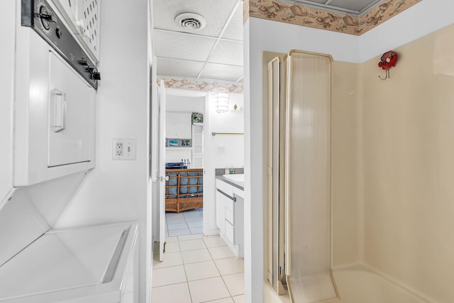 bathroom featuring tile patterned flooring, vanity, a paneled ceiling, and walk in shower