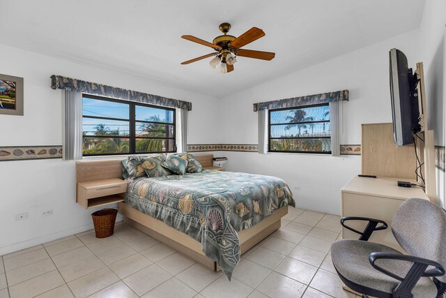 bedroom with vaulted ceiling, light tile patterned floors, and ceiling fan