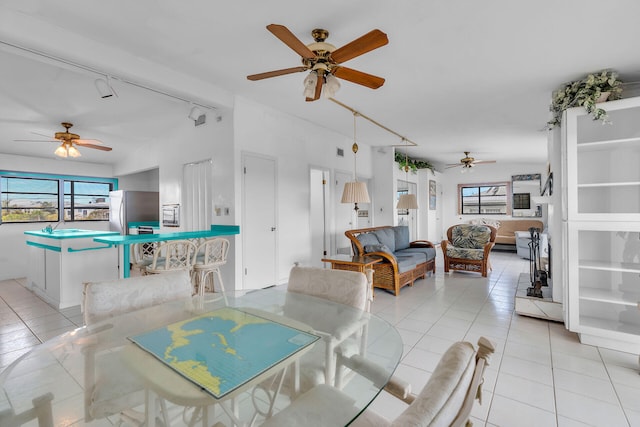 tiled dining area with ceiling fan and rail lighting