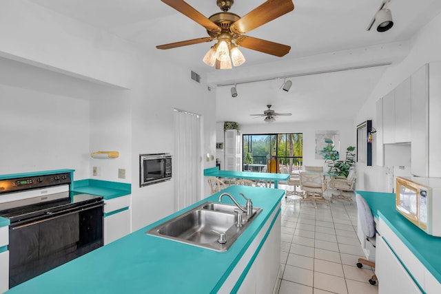 kitchen with sink, track lighting, white cabinets, and electric stove