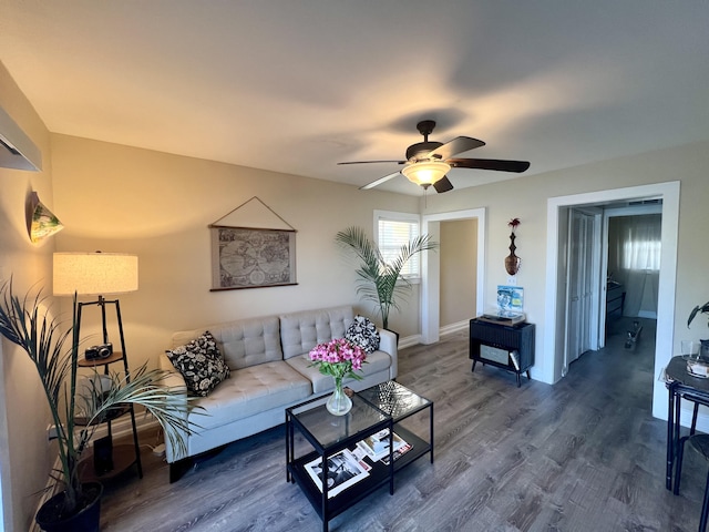 living room featuring ceiling fan and dark hardwood / wood-style flooring