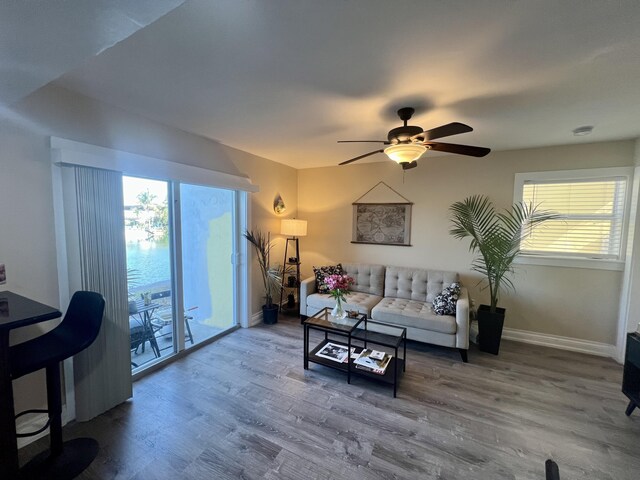 living room featuring wood-type flooring and ceiling fan