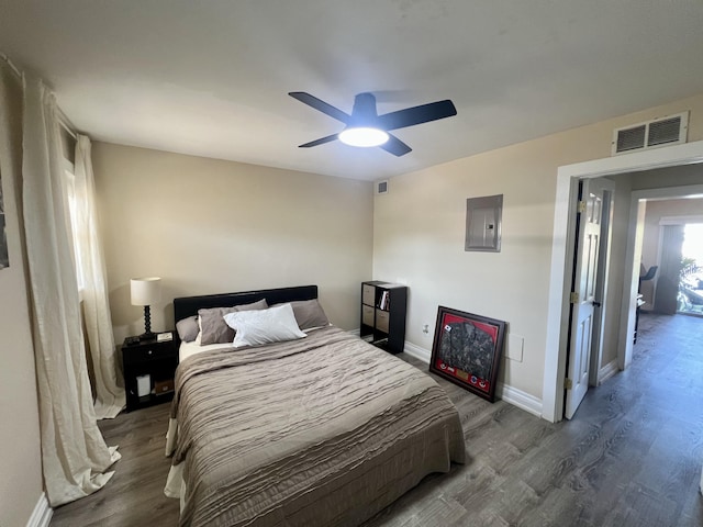 bedroom with ceiling fan, electric panel, and dark hardwood / wood-style flooring