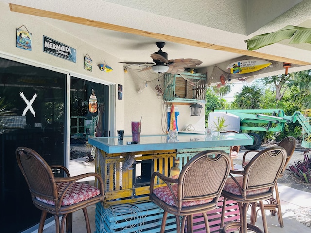 view of patio featuring exterior bar and ceiling fan